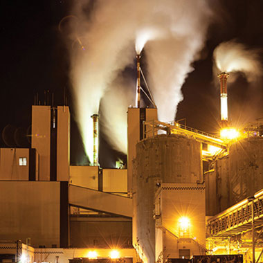 Une usine de papier s'allume la nuit. Les usines de papier utilisent le sulfite de sodium comme agent d'évacuation de l'oxygène pour traiter l'eau acheminée vers les chaudières à vapeur, afin de prévenir la corrosion.