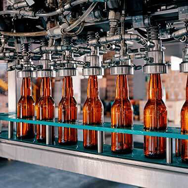 Een productielijn van glazen flessen in een drankenfabriek is voorbeeld van hoe troebelheid de uiteindelijke smaak en kwaliteit van producten kan beïnvloeden.